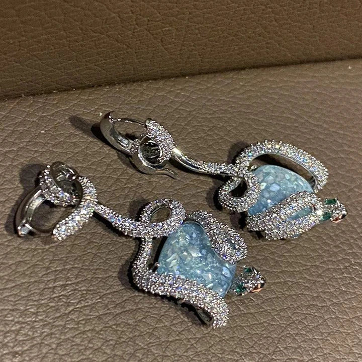 Sophisticated snake-inspired luxury earrings in a copper finish with inlaid gems and semi-precious stones