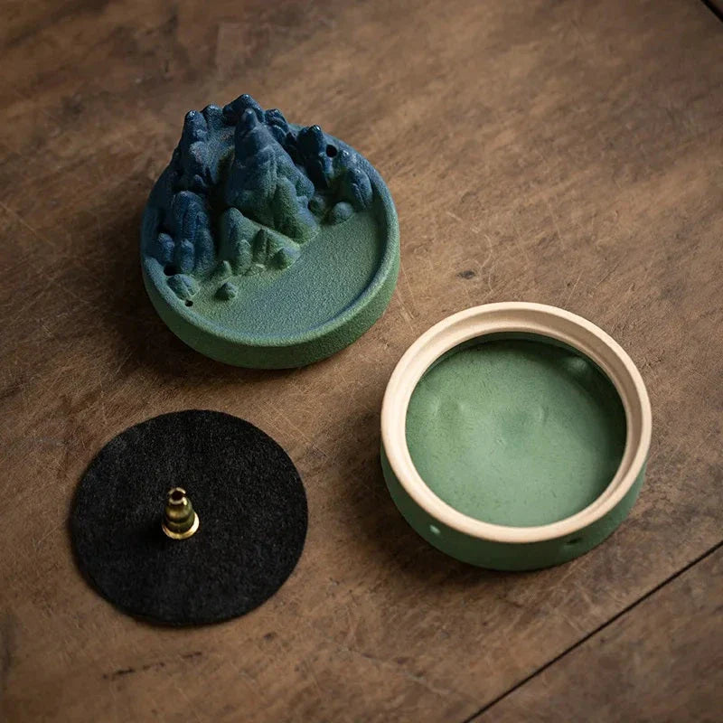 Elegant ceramic incense burner with a tranquil mountain and river design, creating a serene visual display