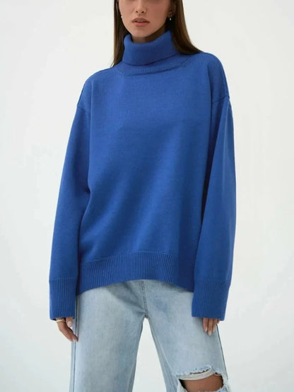 Cosy oversized knitted pullover in blue, featuring a classic turtleneck collar and drop-shoulder silhouette for maximum comfort and style.