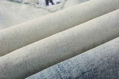 Stylish ripped denim jeans with a unique black and white patch design, perfect for British gentlemen